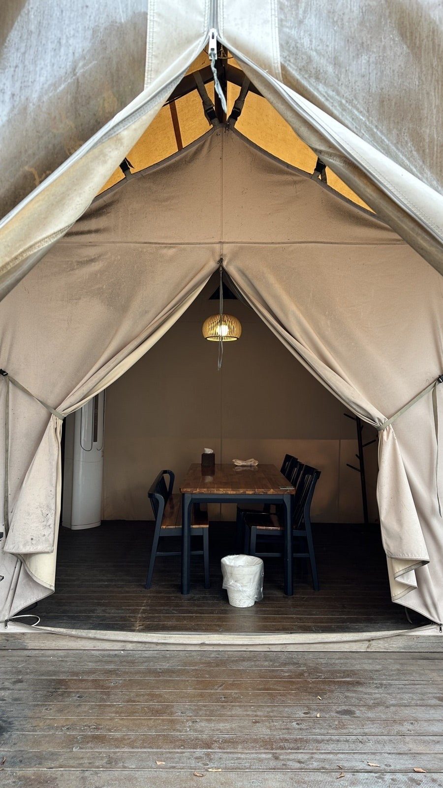 Open day-use glamping tent with a table and grill beneath a canvas canopy