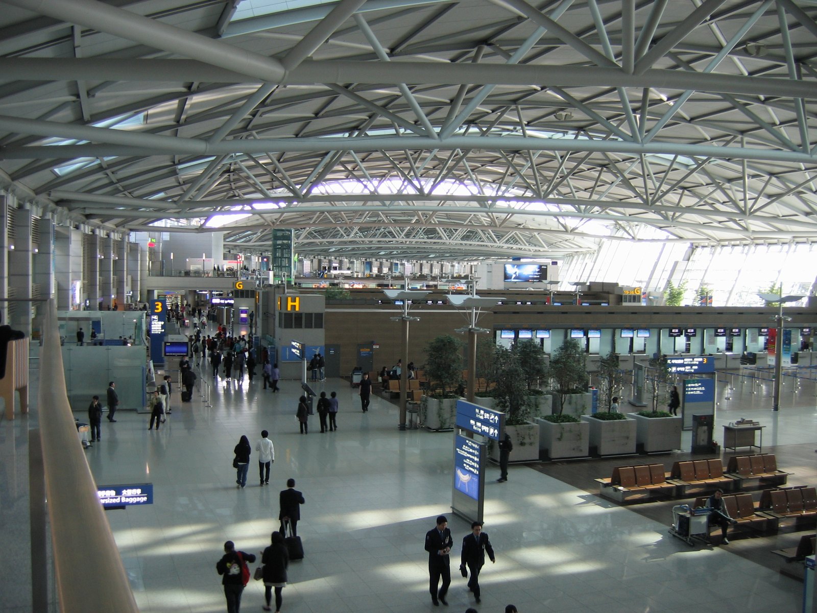 The departures concourse at Incheon International Airport with check-in desks under the steel-truss roof